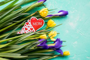 Anneler Günü için bir buket nergis, mor süsen çiçekleri ve üzerinde 