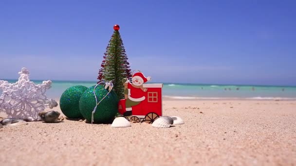 在沙滩上的圣诞树，白色热带沙滩上的礼物天堂海滩。热带节日快乐。圣诞快乐，新年快乐。阳光明媚的天气。Sand.copy space — 图库视频影像
