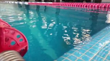 Pistlerle yüzmek için mavi suyla yüzme havuzu, yüzme yollarıyla temiz suya yakın yüzme yarışı, su sporları, aktif yaşam tarzı için profesyonel yüzücü.