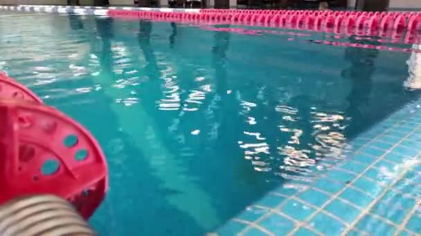 Úszómedence kék vízzel sportoláshoz sínpályás úszáshoz, közelkép a tiszta vízhez a medencében úszósávokkal.Profi úszó felkészülés a versenyre, vízi sportok, aktív életmód — Stock videók