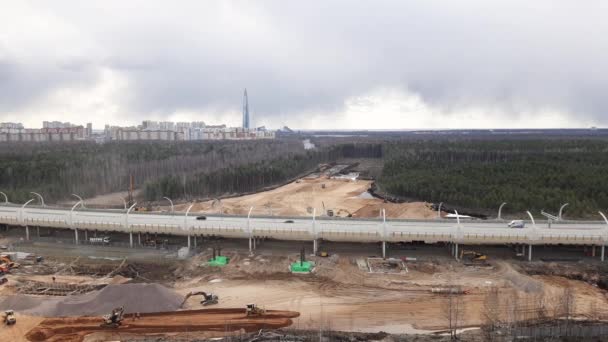 Petersburg, Rosja, 3 marca 2021.Koparka przemysłowa na otwartej drodze ładuje Rock And Earth On Dump Truck. Koparka wiadro kapie i ładunki.Budowa drogi. — Wideo stockowe