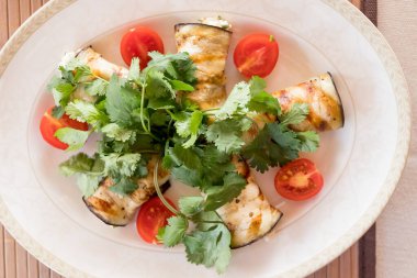 Peynirle doldurulmuş lezzetli patlıcan ruloları. Aperatif. Krem peynirle doldurulmuş patlıcan, sarımsak ve fındık, domates.