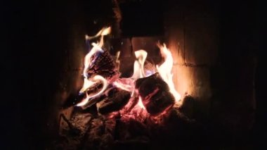 Alev alev yanan eski şömineyi ısıtıyor odun yakıyor, kömür külünde kağıt harfler yazıyor. Romantik şömine. Evdeki şöminede yanan odunlar. Ev sıcaklığı..