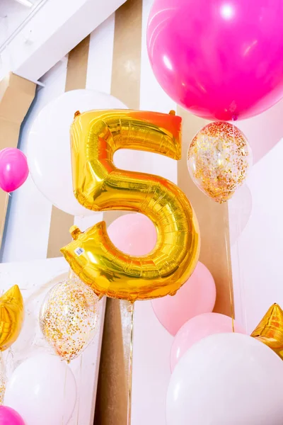 Barn födelsedag dekorationer 5 år nummer, vit rosa luft ballonger.Stor gyllene boll av nummer fem på fest inredning bakgrund. Ljus hälsning zon för en semester, årsdag, födelsedag. — Stockfoto