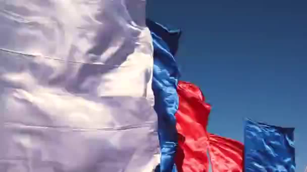 Die russische Flagge weht im Wind gegen den blauen Himmel. Die Nationalflagge der Russischen Föderation. Wimpel oder Abzeichen des Nationalpatriotismus und der Unabhängigkeit. — Stockvideo