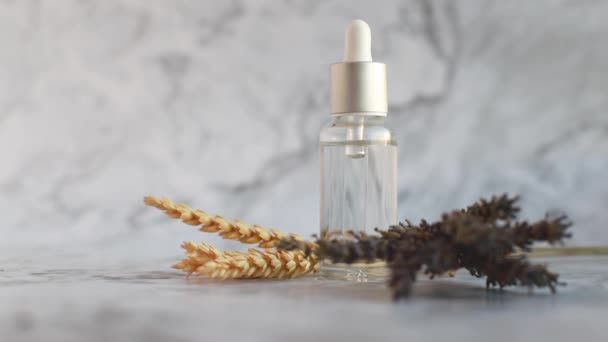 Beauté hydratant essence en bouteille de verre compte-gouttes d'huile. Sérum hydratant, vitamine pour la peau du visage. Goutte huileuse tombe de pipette cosmétique sur fond de marbre. — Video