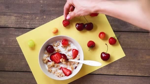 Café da manhã saudável granola de aveia com mirtilos, morangos e iogurte grego.Café da manhã vegetariano. Farinha de aveia, muesli com morangos e cereja em tigela sobre fundo de madeira.Copiar espaço — Vídeo de Stock