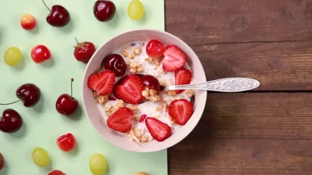 Hälsosam frukost havregryn med blåbär, jordgubbar och grekisk yoghurt.vegetarisk frukost. Havregryn, müsli med jordgubbar och körsbär i skål över träbakgrund.Kopiera utrymme — Stockvideo
