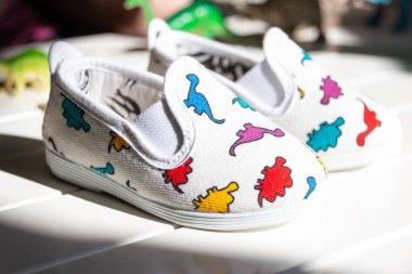 Çocuklar beyaz arka planda yaz mokasenleri. Çocuklar için modaya uygun pamuklu ayakkabılar. Bir çift modayı takip eden kadın ayakkabılar. Alışveriş ve satış konsepti.