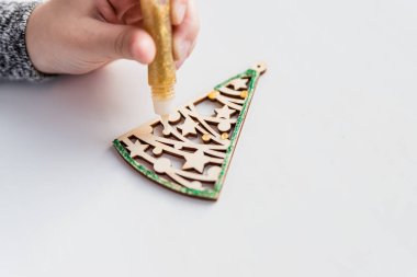 Boyama için ahşap Noel ağacı, beyaz arka planda boya ve hediye kutusu. Sanat projesi. Noel hediyesini kendi ellerinle yaratma fikri. Küçük çocuk ahşap oyuncakları süslemek.