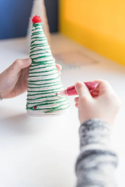 Mutlu Noeller ve mutlu yıllar. Çocuk oyunu konsepti. Tatilde kendi ellerinle yaptığın el sanatları. Yaratıcı bir Noel ağacı. Ev dekoru