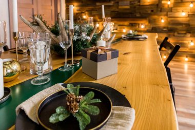 Noel için sade dekorasyonlu şenlik masası. Yeni yıl tatilleri, kutlamalar, modern iç tasarımlardaki dekorasyonlar. Sofra takımı, eko tarzı, mumlar ve sıcak ateş ve kozalaklı brunch.