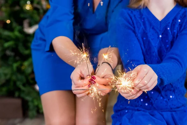 Família celebrando feriados de Natal, festa pessoas segurando faíscas, luzes festivas para o ano novo ou aniversário.Brilhando faíscas em mãos.Fogos de artifício queimando nas mãos. Boas festas. — Fotografia de Stock