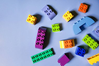Pembe arka planda renkli plastik bloklar, metin için kopyalama alanı. Düz yatıyordu. Üst düzey çocuk inşaat seti. Geometrik şekilli çocuk binası. Öğrenim ve eğitim kavramı.