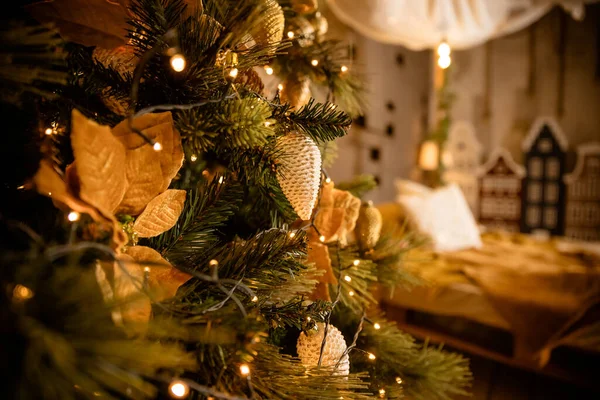 Geschmückter Weihnachtsbaum auf verschwommenem, glitzerndem und märchenhaftem Hintergrund. Festliche Tannenzweige mit goldglänzenden Kugeln, Kugeln, Weihnachtsschmuck und hellen, warmen Lichtern, Girlanden. — Stockfoto