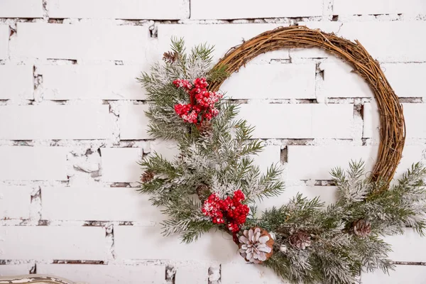 Tradycyjny jasny świąteczny wieniec wiszący nad kominkiem, na białej ceglanej ściance.Christmas koncepcja, nowy rok decor.room w stylu Loft.Copy przestrzeni — Zdjęcie stockowe