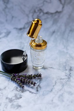 Pipet damlacıklı eko mineral yağı. Şeffaf hyaluronik serum jeli ve cilt bakımı konsepti. Kozmetik pipeti ve bir şişe kozmetik ürünü, hyaluronik asit. Peptit ve kolajenle kozmetik.