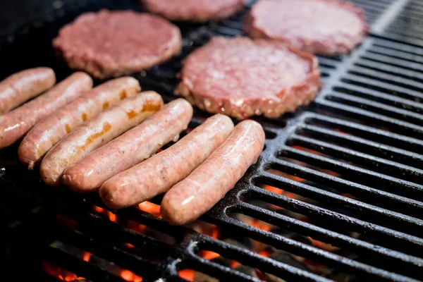 Hamburgers on Grill with Dancing Flames Cooked to Perfection.A closeup of some fresh and juicy hamburgers cooking on the grill.Beef burgers being cooked — Stock Photo, Image