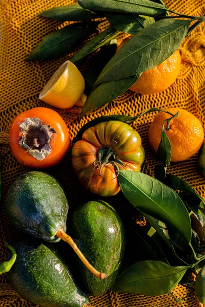 Πράσινα και πορτοκαλί φρούτα και λαχανικά σε υφασμένη κίτρινη κουβέρτα Φωτογραφία Αρχείου