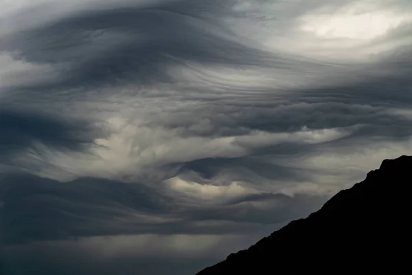 Een Stormachtig Weerfront Met Dikke Grijze Wolken Met Een Bergsilhouet — Stockfoto