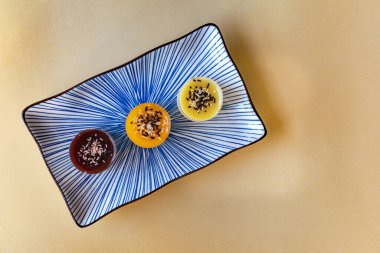 Üçlü bir peynirli kek tabağın sol tarafında çeşitli lezzetlerde tatlılar var.