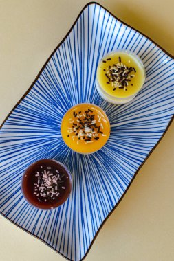 Üçlü bir peynirli kek tabakta çeşitli aromalı tatlılar yakın plan portresi. 