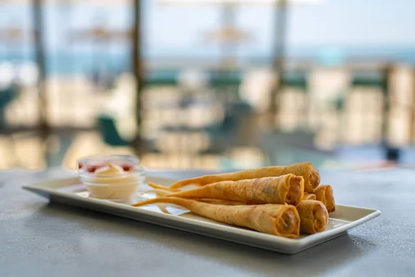 在地中海沿岸的海滩酒吧里 一盘美味的虾仁春卷 配上酱汁 — 图库照片