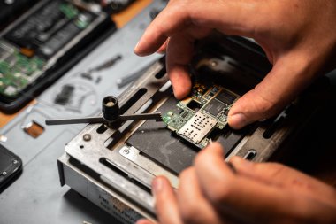 Teknisyen masaya elektronik cihaz monte ediyor.