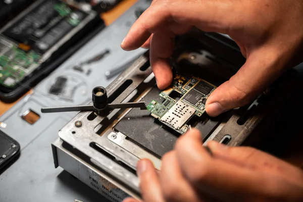 Ingeniero técnico montar dispositivo electrónico en la placa de hierro en la mesa Fotos De Stock Sin Royalties Gratis