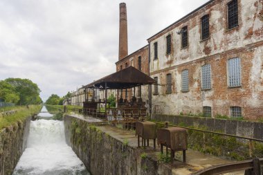 Cascade along the Naviglio Pavese, canal from Milan to Pavia, Lombardy, Italy, with historic buildings