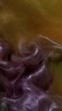 Dikey video. Sıvı pigmenti. Duman mürekkebi. Odaklanmamış mor turuncu renkli su kıvrımlı akrilik soyut koyu siyah arkaplan üzerinde akıyor.