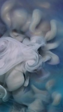 Dikey video. Pırıltılı sis. Işıl ışıl geçmiş. Odaklanmamış mavi mor renkli parlak akrilik parçacıklar soyut sanat eserlerine yayılan mürekkep dumanı.