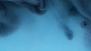 Mürekkep darbesi. Duman boyası. Mavi suda siyah dalga pigmenti döküldü. Renk akışı spiral boyası çözünmüş soyut kıvrım arkaplanını çözer.