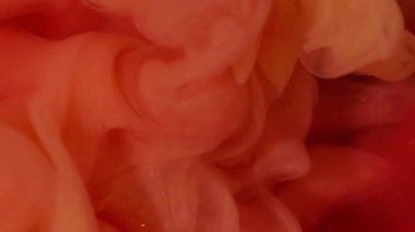 Mürekkep darbesi. Duman boyası. Kırmızı köpüklü suya turuncu dalga pigmenti döküldü. Renk akışı çözünmüş boya soyut kıvrım arkaplanını çözer.