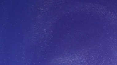 Işıldayan sanat suyu. Sihirli akış. Mor boya rengi sıvı çözülmüş fırıl fırıl dönüyor. Spiral emülsiyon pigmenti fantezi twist karışımı soyut arkaplan.