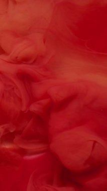 Dikey video. Sis rengi. Sıvı mürekkep. Odaklanmamış kırmızı pembe sis dokusu soyut sanat arka planında dalgalanan su sıçratıyor..