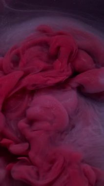 Dikey video. Pırıltılı sis. Işıl ışıl geçmiş. Odaklanamayan mor renk parlak kimyasal partiküller soyut kara sanat üzerine yayılan mürekkep dumanı..