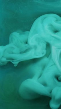 Dikey video. Duman akışı. Soyut mürekkep. Odaklanmamış yeşil renkli duman buhar dokusu sanat arka planında yüzen kimyasal sıvıyı karıştırır.