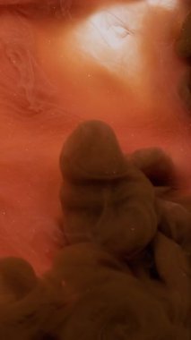 Dikey video. Sigara arkaplanı. Buhar bulutu. Odaklanmamış turuncu bronz rengi beyaz soyutlamada büyüyen su patlaması akışında mürekkep sıçraması..