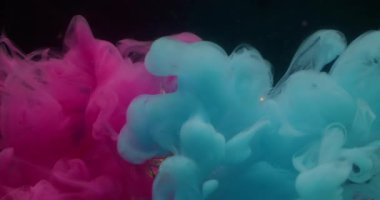 Duman patlaması. Eski bir ampul. Hasarlı camda parlayan bir çelenk. Siyah arkaplan üzerinde pembe mavi duman harmanı renk mürekkebi soyut gece suyu