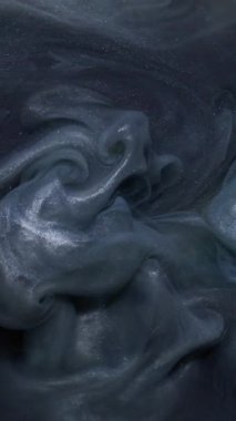 Dikey video. Parıldayan sis. Köpüklü duman. Soyut koyu siyah arkaplanda dönen su akrilik bulutunda çözünmüş mavi mor renk boya.