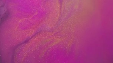 Bulanık mürekkep akışı. Parlak pigmentler. Soyut arkaplana yayılan mor pembe altın renkli simli partiküller..