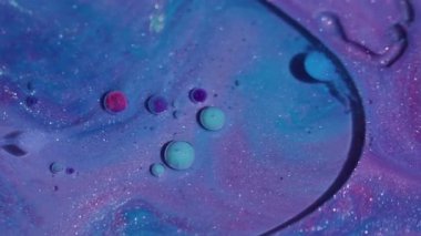 Parlak emülsiyon. Mürekkep sanatı. Odaklanmamış mavi pembe renkli parlak yağ kabarcıkları soyut akrilik arka planda yayılan sıvı yuvarlak doku..