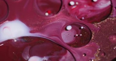 Kabarcık dokusu. Mürekkep yağı suyu. Soyut akrilik arkaplan üzerinde yüzen kırmızı, beyaz, altın rengi yuvarlak, simli sıvı akışı.