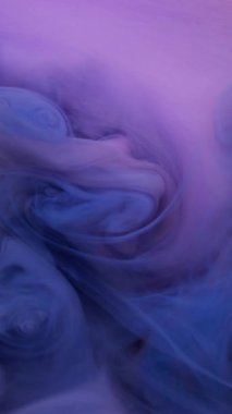 Dikey video. Mürekkep su sıçratır. Akışkan bulut. Soyut sanat arka planında titreşen odaksız mavi pembe karışık akış sıvısı.