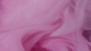 Buhar karışımı. Sis mürekkebi kıvrılıyor. Sanatta karıştırılmış pembe beyaz boya çözünmüş sıvı. Hipnotik ışıltılı akış rengi kıvrımlı soyut siyah arkaplan.