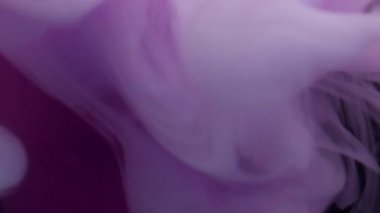 Buhar karışımı. Buhar mürekkebi. Siyah arkaplana yayılan beyaz pembe sıvı girdap. Bulanık renk soyut ışıldayan pigment suyun altında yüzüyor.