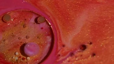 Parlak emülsiyon. Mürekkep sıçraması. Odaklanmamış turuncu pembe renk akışı yağlı sıvı köpükler soyut yaratıcı arka planda yayılıyor.