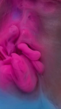 Dikey video. Su altı buharı. Arkaplanı boya. Bulanık pembe mor renkli duman pırıltı girdap su sisi sanat soyutlamasında süzülüyor.