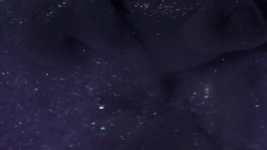 Mürekkep darbesi. Duman boyası. Mor köpüklü suda siyah dalga pigmenti döküldü. Renk akışı boyası odaklanmış kozmik soyut kıvrım arkaplanı.